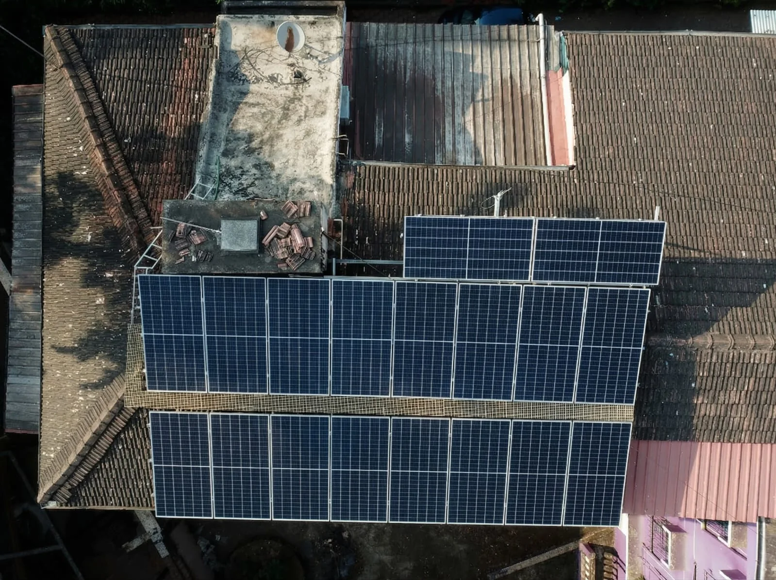 Large solar array across a weathered tiled roof